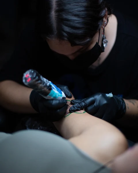 Detalle del trazo fino y máquina de tatuaje
