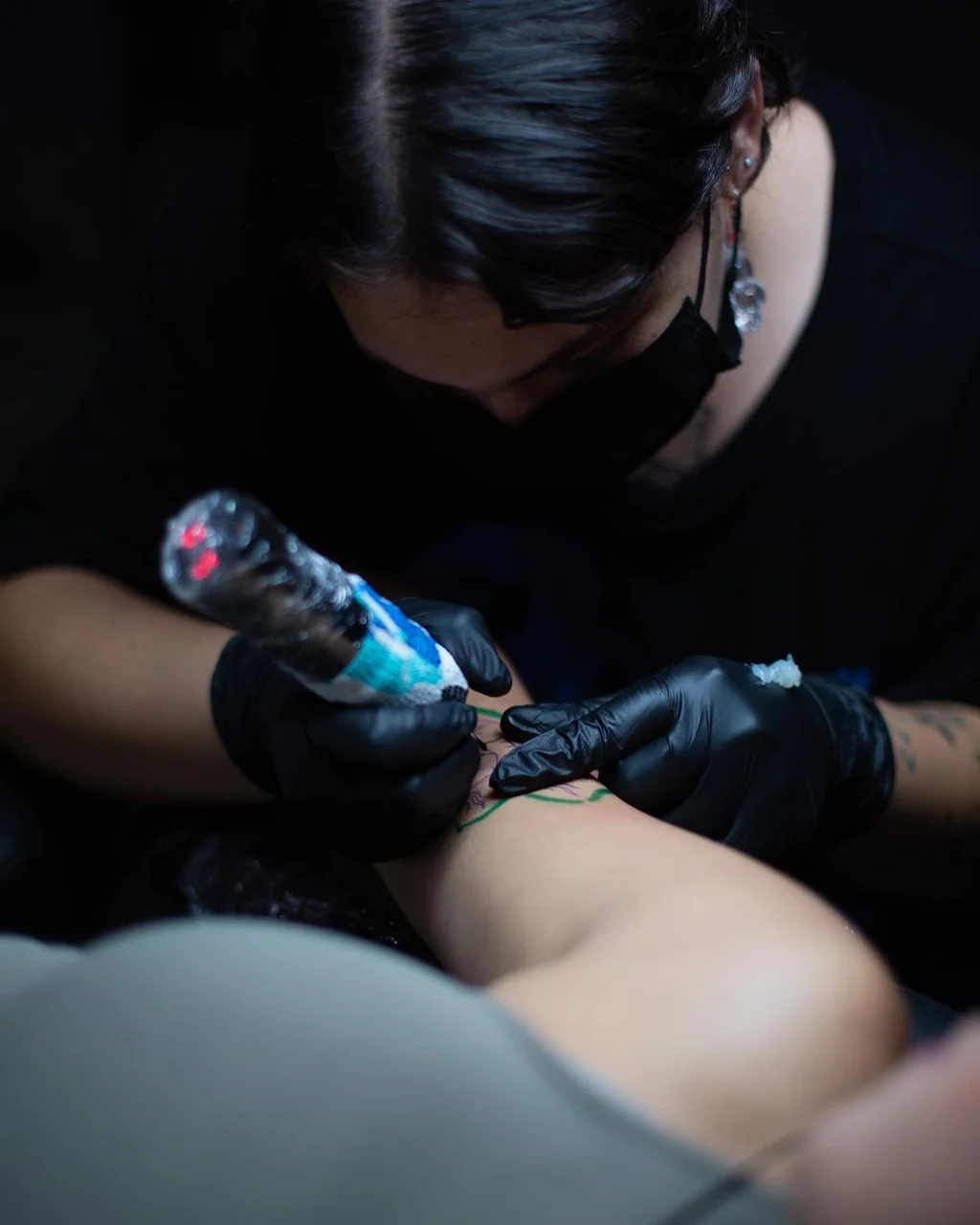 Claudia Flocco realizando un tatuaje fine line con máquina en el estudio