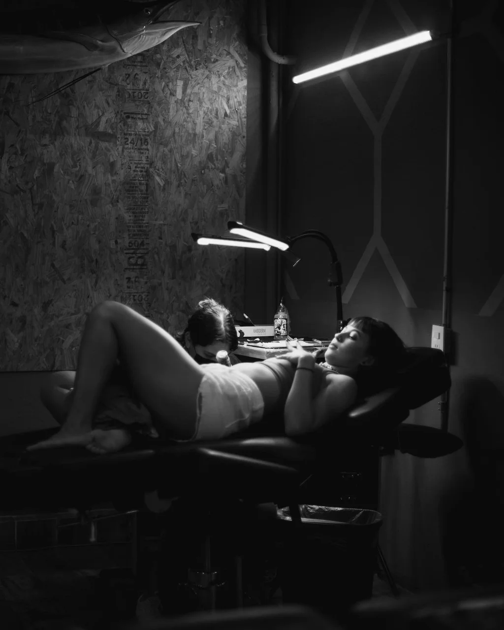 Claudia Flocco tatuando en sesión en blanco y negro